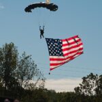 Parachutist lands the flag at the start-finish straight, Road Atlanta, Petit Le Mans, 2011