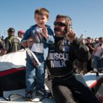 Young boy stands aboard the Muscle Milk Aston Martin Lola P1 car